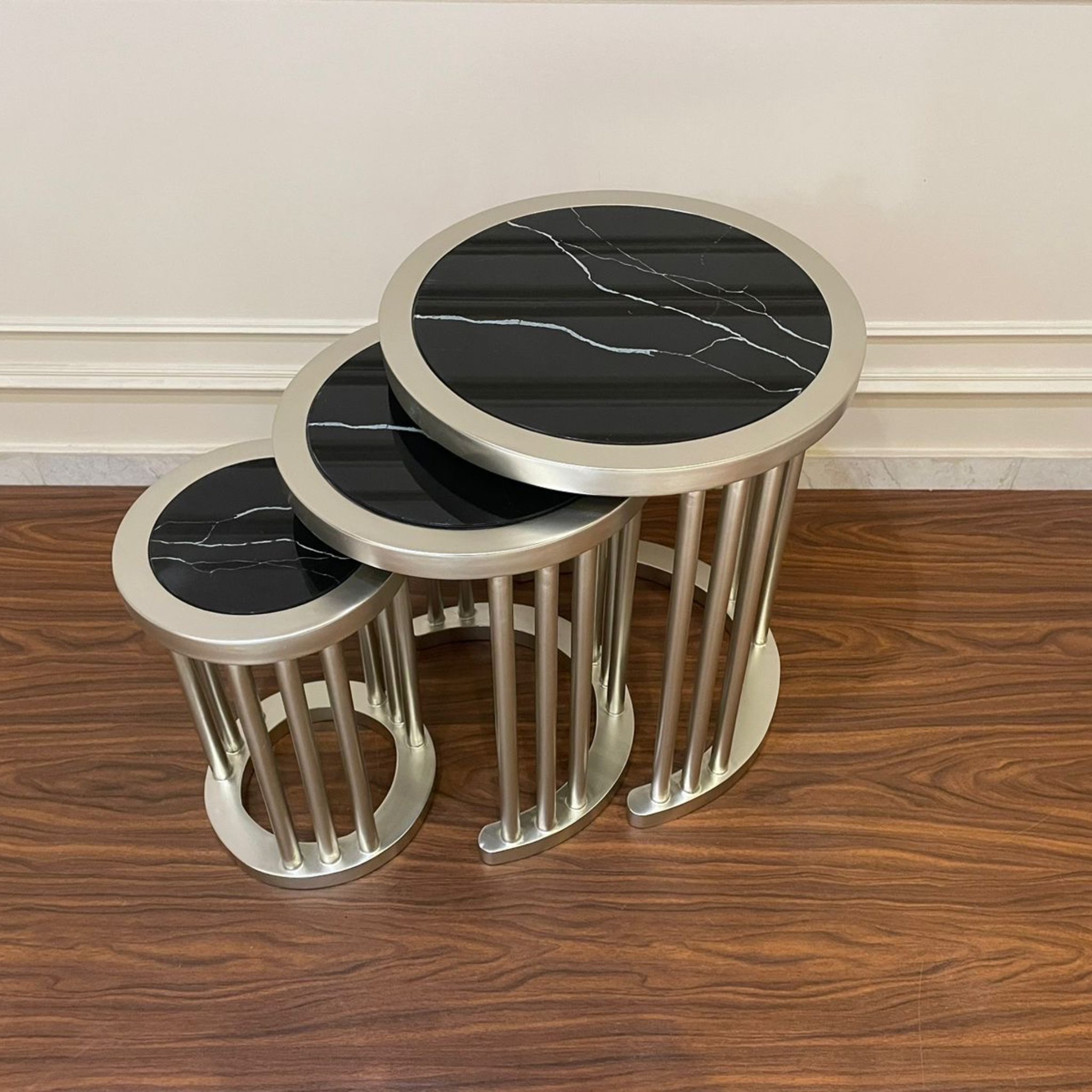 طقم ترابيزات مودرن شامبين فضي بزجاج رخامي - طقم ترابيزات جانبية بتصميم عصري أنيق، يتكوّن من ثلاث ترابيزات متداخلة بلمسة شامبين فضي تضيف فخامة لأي مساحة. مناسب للليفنج أو الاستقبال أو حتى كمكمل ديكور بجانب الركنة مصنوع من خشب الزان الطبيعي، والقرص من زجاج شبيه بالرخام الأسود بخطوط بيضاء أنيقة، ليمنحك شكل فاخر بخامة عملية وسهلة التنظيف الخاماتخشب زانزجاج شبيه بالرخامدهان شامبين فضي المقاساتالعرض 50 سم × الارتفاع 60 سم