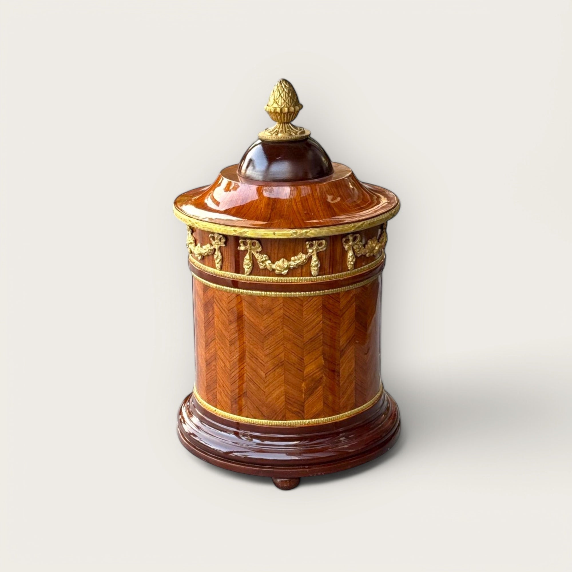 سلّة مهملات كلاسيكية فاخرة بتصميم خشبي وزخارف نحاسية - سلّة مهملات بتصميم كلاسيكي راقٍ مصنوعة من الخشب الطبيعي، مزودة بزخارف نحاسية ذهبية تضفي لمسة من الفخامة. تتميز بغطاء علوي مزخرف وأنيق، مما يجعلها مثالية للاستخدام في المكاتب، الصالونات، أو الغرف الكلاسيكية حيث تجمع بين العملية والجمال. الارتفاع: 50 سم القطر: 30 سم