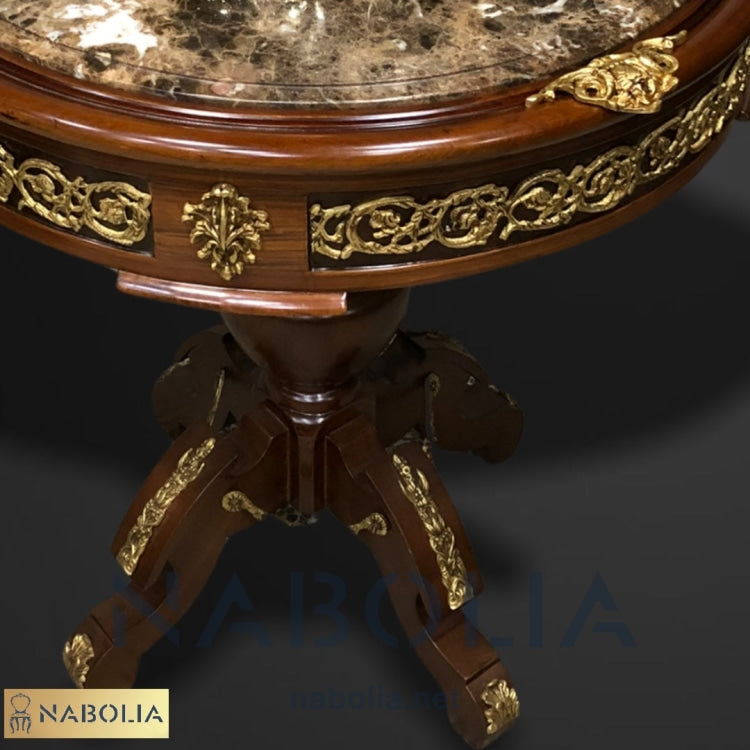 ترابيزة دائرية مطعمة بالنحاس وقرصة رخام امبرادور - قطعة فنية أنيقة بتصميم كلاسيكي فاخر، مصنوعة من الخشب الطبيعي ومطعمة بالنحاس المشغول يدويًا بدقة عالية. سطح الطاولة مصنوع من رخام امبرادور الغامق الذي يعزز من فخامتها ويمنحها لمسة راقية. القاعدة المتينة بتصميم كلاسيكي فخم تضيف ثباتًا وأناقة، ما يجعلها مناسبة لتكون طاولة جانبية أو قطعة ديكور مميزة في أي مساحة داخلية. الخاماتخشب طبيعي عالي الجودةنحاس مشغول يدويًارخام امبرادور غامق المقاساتالعرض: 70 سمالطول: 70 سم