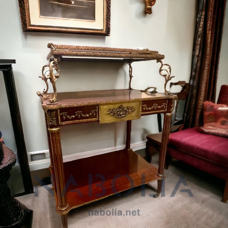 عربة ترولي فرنسي طراز لويس الخامس عشر - عربة تقديم بتصميم فرنسي فاخر على طراز لويس الخامس عشر، مصنوعة من خشب طبيعي مطعم بالنحاس، مع تفاصيل دقيقة تعكس الذوق الكلاسيكي الراقي. متعددة الاستخدامات، مثالية لتقديم الشاي أو المشروبات، وتضفي لمسة ملكية على أي مساحة الخاماتالهيكل: خشب طبيعيالتشطيب: قشرة طبيعيةالزخرفة: تطعيم يدوي بالنحاس المقاساتالعرض: 67 سمالارتفاع: 105 سمالعمق: 50 سم